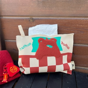 Close-up of knit tissue holder featuring bear motif and red checkered pattern for home decor