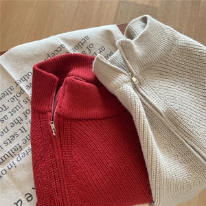 Dettaglio di sciarpe in maglia spessa con cerniera in rosso e beige caldo