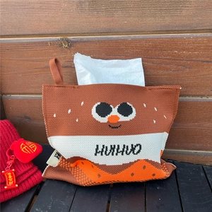 Close-up of a handmade knitted tissue cover with cartoon eyes and a convenient hanging loop