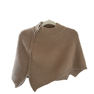 Maglione a mantella in maglia marrone latte con cerniera metallica asimmetrica su sfondo bianco