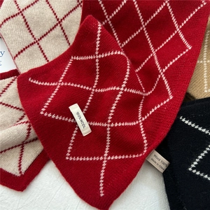 Gros plan d'écharpes 100 % laine à losanges avec texture tricotée et étiquettes logo
