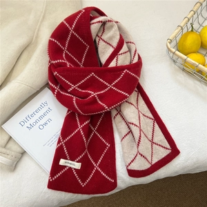Détail d'écharpe en laine à losanges rouge et blanc avec étiquette premium 100% laine