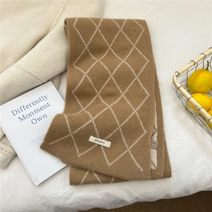 Détail d'une écharpe en laine 100% avec motif à losanges marron et blanc tricoté