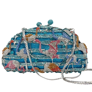 Detailed close-up of blue crystal clutch bag featuring vibrant rhinestone flamingo patterns
