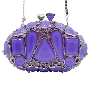 Détail de strass en verre violet et de gemmes mauves sur le sac de soirée argenté