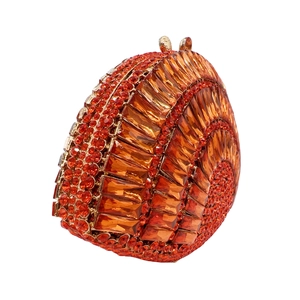Close-up of golden clutch bag with amber rhinestones in shell spiral pattern