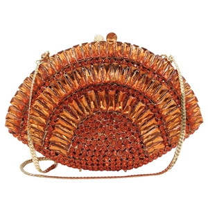 Macro detail of amber rhinestones and gold frame on fan-shaped luxury clutch bag