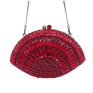 Detail of red hollowed-out evening clutch bag with sparkling rhinestones and metal chain