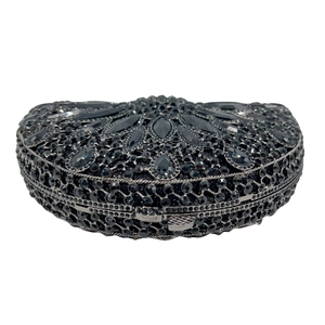Macro detail of black evening clutch bag featuring radiant floral rhinestone patterns