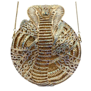 Close-up of gold cobra rhinestone evening bag with sparkling crystals and metal chain