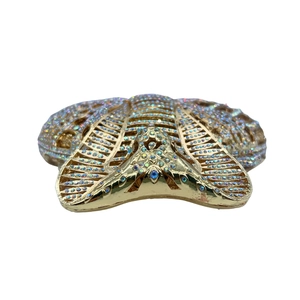 Close-up of sparkling colorful rhinestones on the golden cobra evening clutch bag