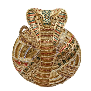 Macro shot of Egyptian cobra head detail on a luxury crystal studded evening clutch bag