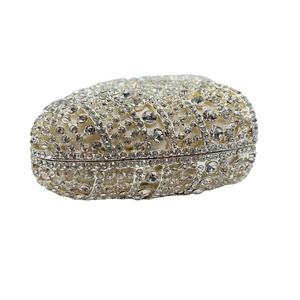 Macro view of crystal encrusted clutch bag with silver metallic radial stripes design