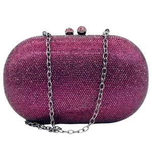 Macro view of purple crystal clutch bag showing dense rhinestone pattern and silver chain