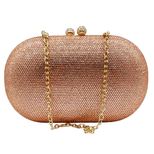 Close-up of champagne crystal clutch bag with diamond clasps and golden chain