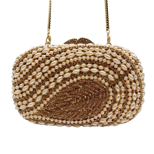 Macro detail of luxury evening clutch with hollow leaf design, pearls and crystals