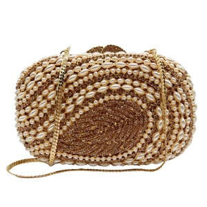 Detailed close-up of crystal evening clutch with leaf pattern and pearl rhinestones