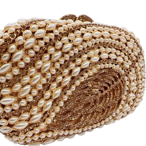 Macro detail of luxury crystal evening clutch with leaf pattern, pearls and gold finish