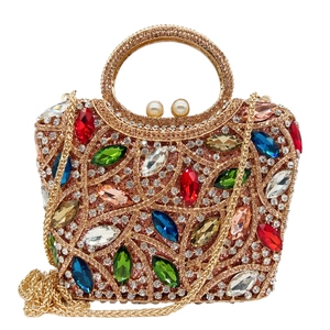 Close-up of gold evening clutch with colorful marquise crystals and pearl closure