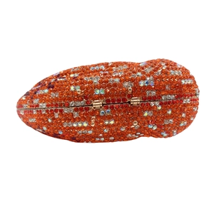 Detailed macro of a lip-shaped crystal evening bag with red and orange rhinestones