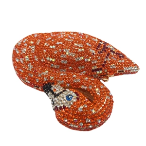 Detailed close-up of crystal swan evening bag with orange and gold rhinestone inlay