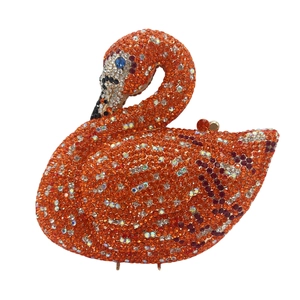Detailed close-up of orange swan-shaped evening bag with shimmering crystal rhinestones