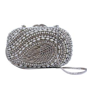Elegant crystal leaf evening bag with faux pearls and silver rhinestones on white background