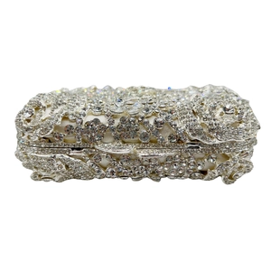 Détail de la pochette en cristal argenté avec motif rose ajouré et diamants étincelants
