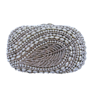 Detail of elegant crystal leaf pattern and faux pearl embellishments on evening clutch