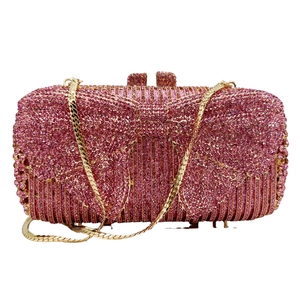 Detail of rose pink evening clutch with bow rhinestone pattern and gold chain strap