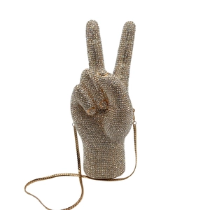 Macro detail of victory hand crystal evening bag with champagne rhinestones and gold chain