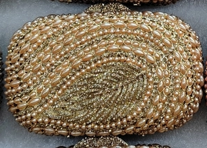 Detail of evening clutch bag featuring champagne faux pearls and shimmering crystals