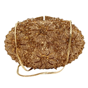 Macro shot of gold crystal floral hollow design on luxury evening clutch with chain strap