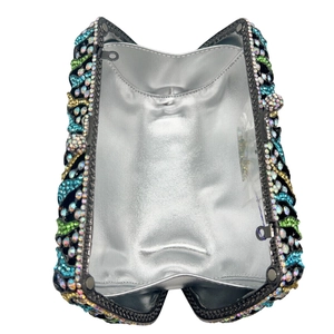 Close-up of sparkling wave pattern rhinestones and silver metallic lining in clutch bag