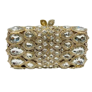 Detail of crystal clutch bag featuring pear-cut stones and golden leaf metal clasp
