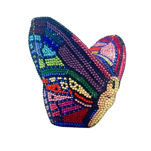 Macro view of crystal-encrusted butterfly clutch bag with colorful rhinestones