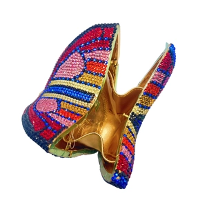Macro detail of luxury butterfly clutch showing colorful rhinestones and gold lining
