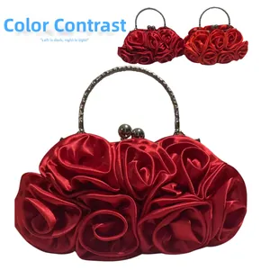 Detail of red satin rose evening bag showing color contrast and silver metal handle
