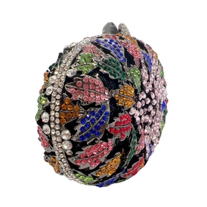 Macro shot of circular evening bag featuring colorful floral rhinestone crystal inlay