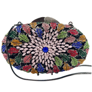 Detailed view of colorful rhinestone patterns and central blue crystal on dinner bag