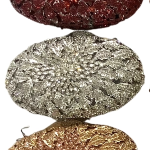 Detailed stack of oval evening clutch bags with shimmering crystal leaf patterns