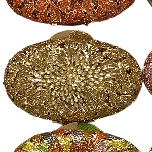 Close-up of golden oval evening bag with intricate crystal rhinestones and floral pattern