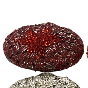 Macro shot of deep red rhinestones in leaf pattern on the sparkling evening clutch bag
