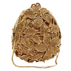 Détail d'une pochette dorée avec motifs floraux en strass 3D et chaîne serpent