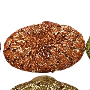 Macro detail of amber rhinestone evening bag with intricate leaf-shaped crystal pattern