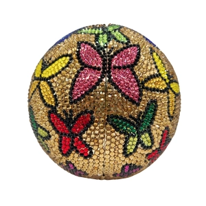Détail macro du sac pochette sphérique en cristal avec strass colorés et motifs papillons