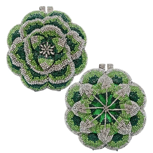 Close-up of floral evening clutch bag with green crystals and silver rhinestone petals