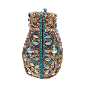 Detail of evening clutch featuring blue rhinestones and gold fish scale metal hollow design