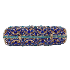 Macro view of blue rhinestone floral pattern on luxury gold metal evening clutch