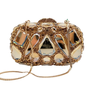Detailed macro view of champagne gold evening clutch featuring sparkling crystals and chain